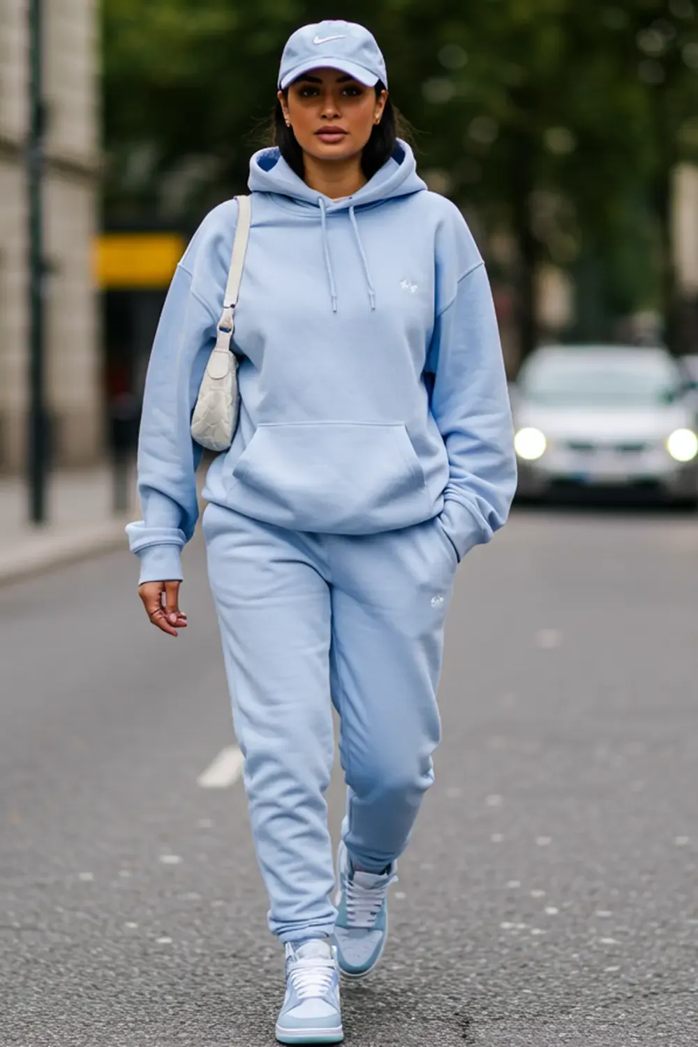 Model showcasing a monochrome pastel blue outfit with matching Nike Dunk Lows, hoodie, and joggers for a chic streetwear look.