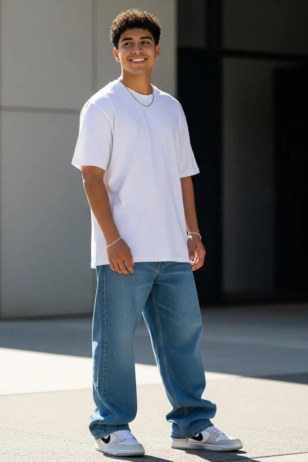 Man wearing Panda Dunk Lows, medium-wash wide-leg jeans, and an oversized white t-shirt, epitomizing a classic cool streetwear look.