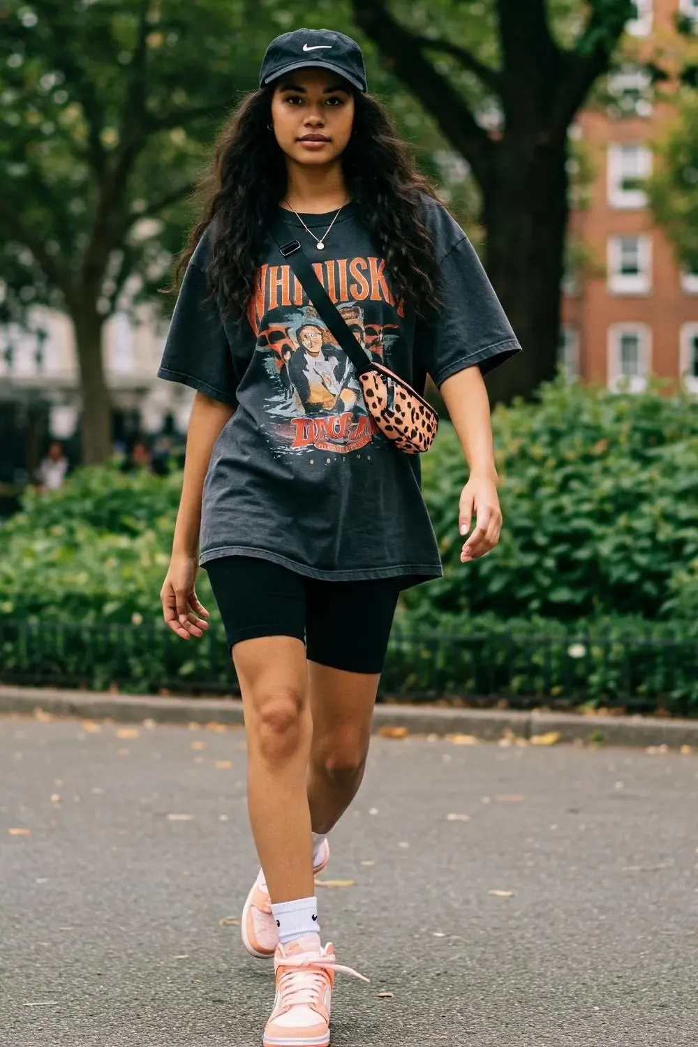 Gen Z model showcasing a sporty summer outfit with Nike Dunk Lows, biker shorts, and an oversized t-shirt.